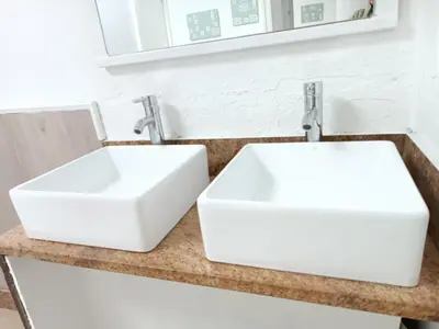 two white sinks on a counter in a bathroom at Hostel Bretema in Lugo