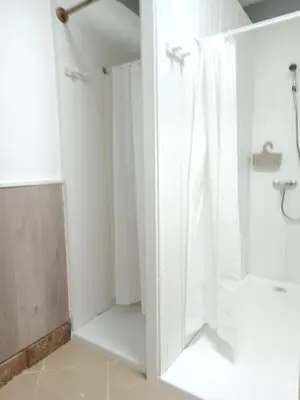 a bathroom with a shower with a white shower curtain at Hostel Bretema in Lugo