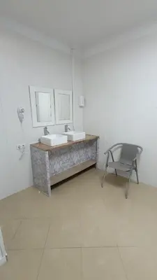 a bathroom with a sink and a chair in it at Hostel Bretema in Lugo