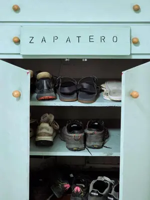 a cabinet filled with lots of pairs of shoes at Hostel Bretema in Lugo