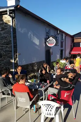 a group of people sitting at tables outside a restaurant at Albergue Ponte Ferreira CAMINO PRIMITIVO Lugo - Ferreira in Lugo