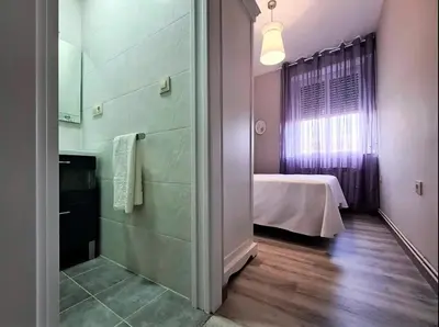 a bathroom with a shower and a bed in a room at Piso Estacion Tren Bus Termas muy luminoso in Ourense