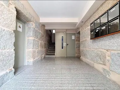 a hallway of a building with a stone wall at Piso Estacion Tren Bus Termas muy luminoso in Ourense