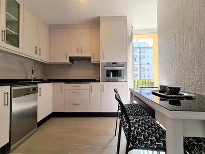 a kitchen with white cabinets and stainless steel appliances at Piso Estacion Tren Bus Termas muy luminoso in Ourense