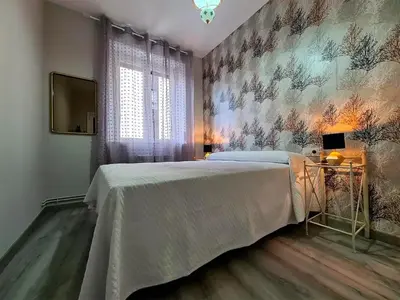 a bedroom with a bed and a wall mural at Piso Estacion Tren Bus Termas muy luminoso in Ourense