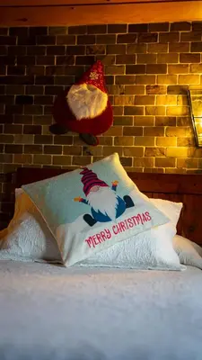 a pillow with a santa hat on a brick wall at Mi Tesoro in Viveiro