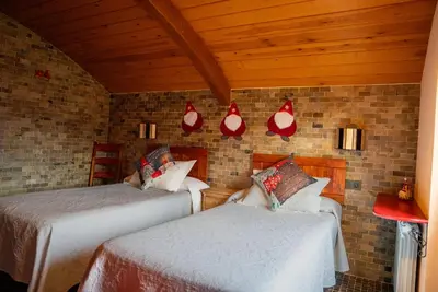a bedroom with two beds and a brick wall at Mi Tesoro in Viveiro