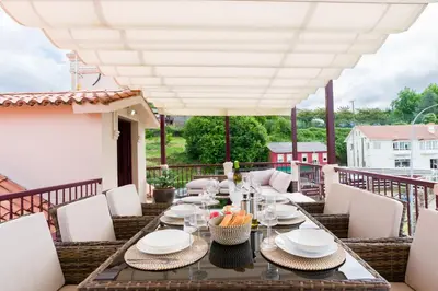 a patio with a table and chairs on a balcony at Ático tipo loft en San Sadurniño. in Santa María La Mayor del Rosario