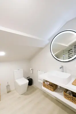 a white bathroom with a sink and a mirror at Ático tipo loft en San Sadurniño. in Santa María La Mayor del Rosario