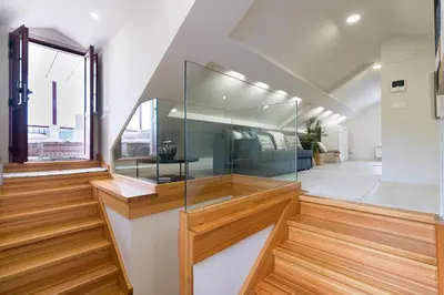 a staircase in a house with a glass wall at Ático tipo loft en San Sadurniño. in Santa María La Mayor del Rosario