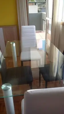 a living room with a glass table and chairs at Coqueto alojamiento cercano a las termas A in Ourense