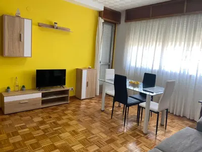 a living room with a dining table and a television at Coqueto alojamiento cercano a las termas A in Ourense