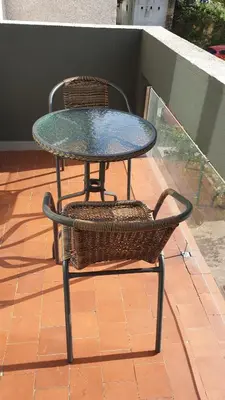 a glass table and a chair sitting on a patio at Coqueto alojamiento cercano a las termas A in Ourense