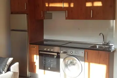 a kitchen with a washing machine and a sink at Coqueto alojamiento cercano a las termas A in Ourense