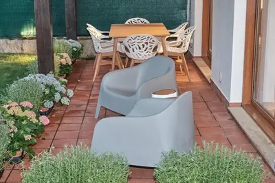 a patio with a table and chairs and flowers at Yuhom, casas con alma. Xacedos 3 in Miño