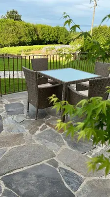 a table and chairs on a stone patio at Caraxolas in Lugo