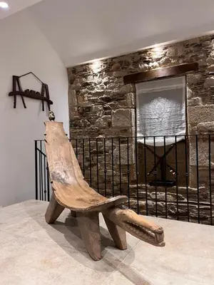 a wooden bench sitting in front of a stone wall at Caraxolas in Lugo