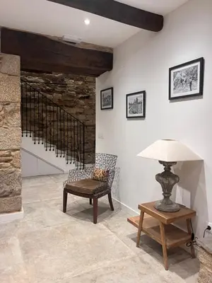a room with a chair and a table and a lamp at Caraxolas in Lugo