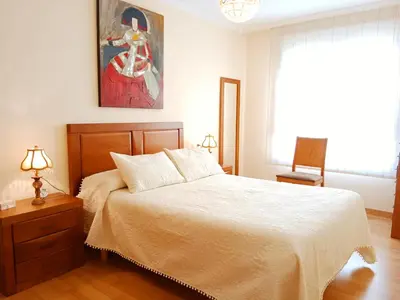 a bedroom with a bed and a painting on the wall at La Casa de Ana in Viveiro