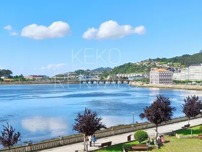 a view of a river with people walking on a sidewalk at La Casa de Ana in Viveiro