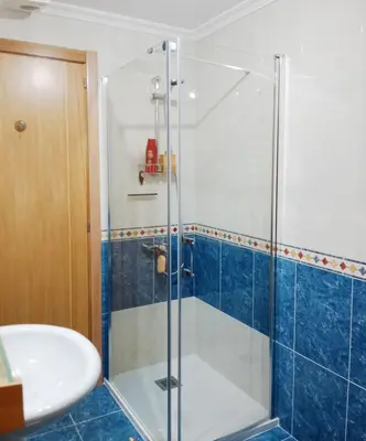 a bathroom with a glass shower and a sink at La Casa de Ana in Viveiro
