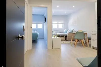 a room with a kitchen and a living room with a table at Apartamentos Nature in Cangas del Narcea