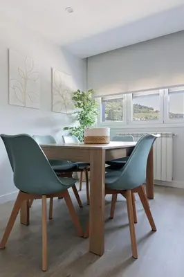 a dining room with a wooden table and chairs at Apartamentos Nature in Cangas del Narcea
