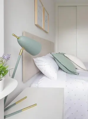 a lamp on a bed with pillows on it at Apartamentos Nature in Cangas del Narcea