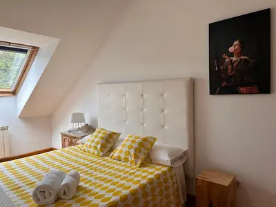 a bedroom with a bed with a yellow and white checkered blanket at Alianza del Castillo in Ponferrada
