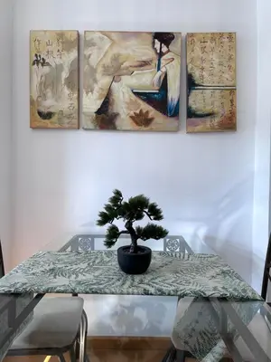 a table with a plant on it with four paintings at Alianza del Castillo in Ponferrada