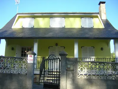 a yellow house with a gate and a fence at Casa con jardín en la playa de Almieiras in Fene