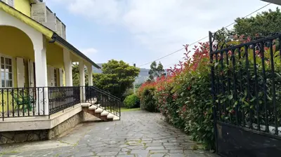 a walkway next to a house with a fence at Casa con jardín en la playa de Almieiras in Fene