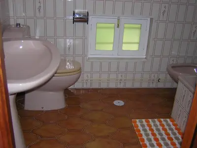 a bathroom with a white sink and a toilet at Casa con jardín en la playa de Almieiras in Fene