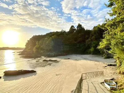 a beach with a boat sitting on the sand at Casa con jardín en la playa de Almieiras in Fene