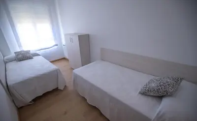 a room with a bed and a couch and a window at Duerming Ría de Viveiro in Viveiro