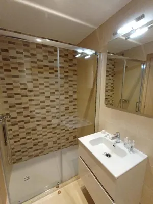a bathroom with a white sink and a shower at Duerming Ría de Viveiro in Viveiro