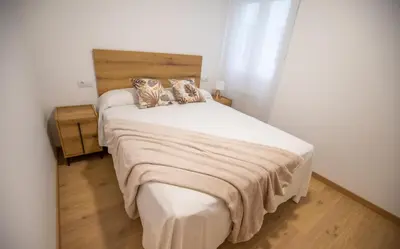 a bedroom with a large white bed with two pillows at Duerming Ría de Viveiro in Viveiro