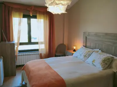 a bedroom with a bed and a window and a chandelier at Casa de Sunny in Parada