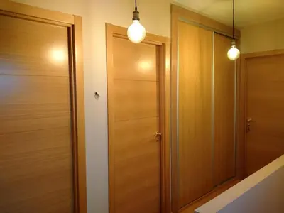 a hallway with two wooden doors and two lights at Casa de Sunny in Parada