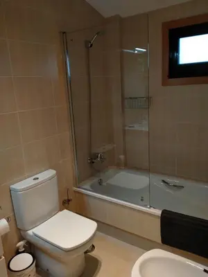 a bathroom with a toilet and a shower and a tub at Casa de Sunny in Parada