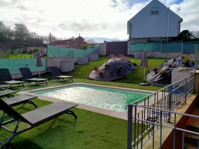 a swimming pool with two chairs and a playground at Casa de Sunny in Parada