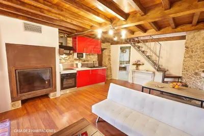 a living room with a white couch and a kitchen at Viveiro Río Pedroso in Vivero