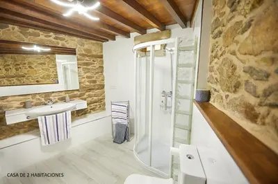 a bathroom with a sink and a glass shower at Viveiro Río Pedroso in Vivero