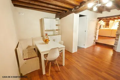 a kitchen and dining room with a white table and chairs at Viveiro Río Pedroso in Vivero
