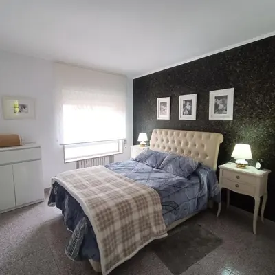 a bedroom with a bed with a blanket and a window at Tu Apartamento Ideal in Ponferrada