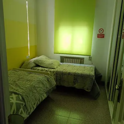 two beds in a room with green walls at Tu Apartamento Ideal in Ponferrada
