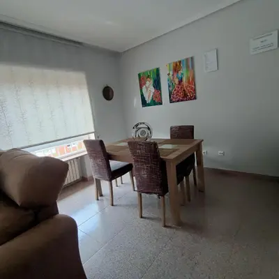 a dining room with a wooden table and chairs at Tu Apartamento Ideal in Ponferrada