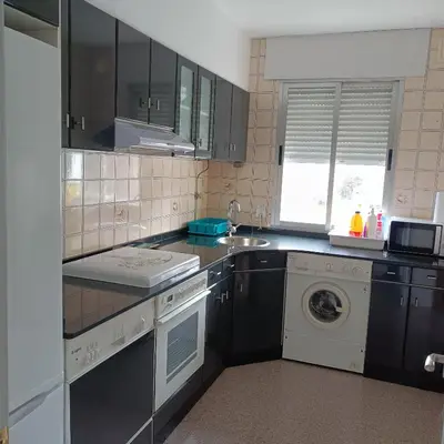 a kitchen with a sink and a washing machine at Tu Apartamento Ideal in Ponferrada