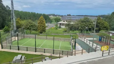 a tennis court in a park with a tennis court at Casiña de Érika in San Cosme de Barreiros