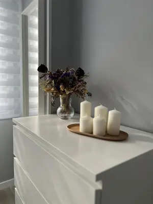 a table with three candles and a vase of flowers at Apartamento da Fraga in Arzúa